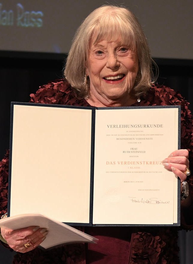 Ruth Steinfeld holding the certificate for the Cross of Merit of the Federal Republic of Germany